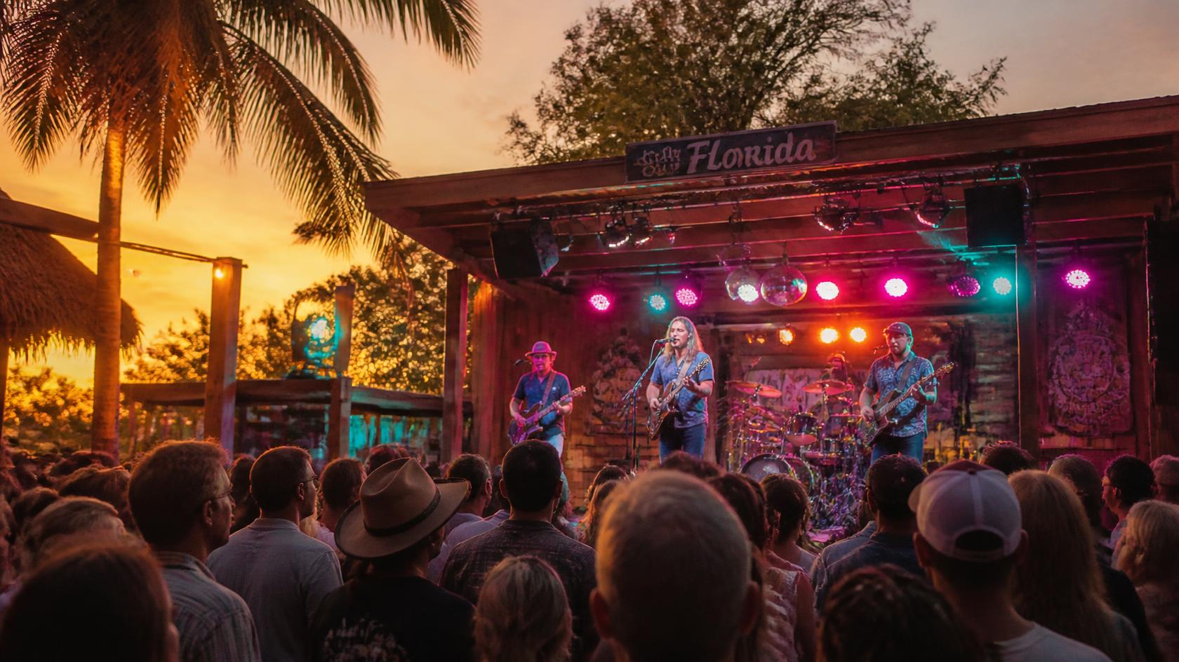Local live music band performing on a small stage during a summer event in Florida.